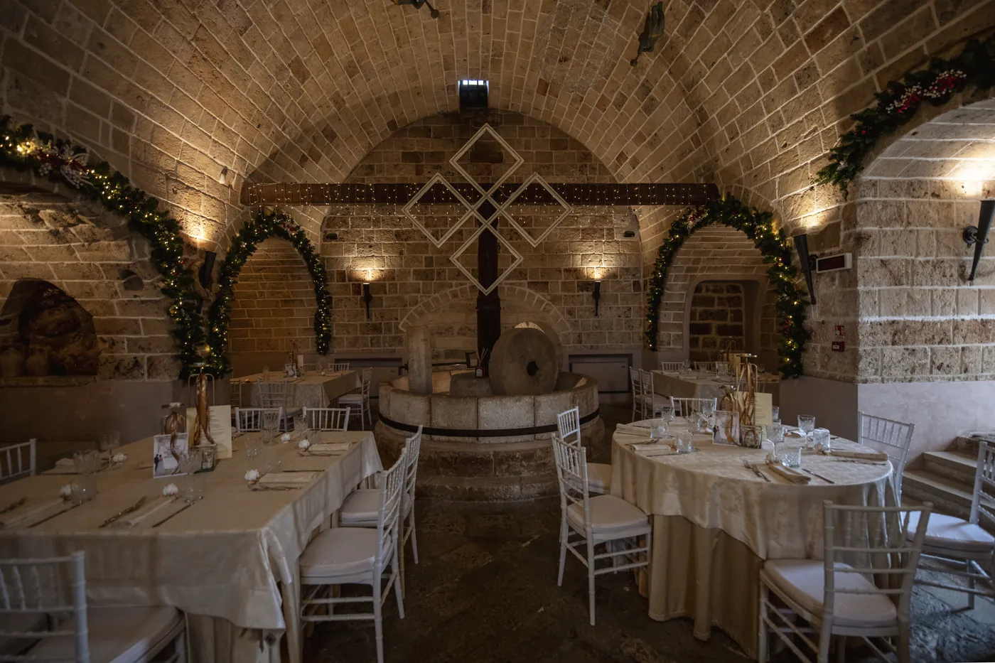 La sala coi tavoli attorno alla macina in pietra del vecchio frantoio