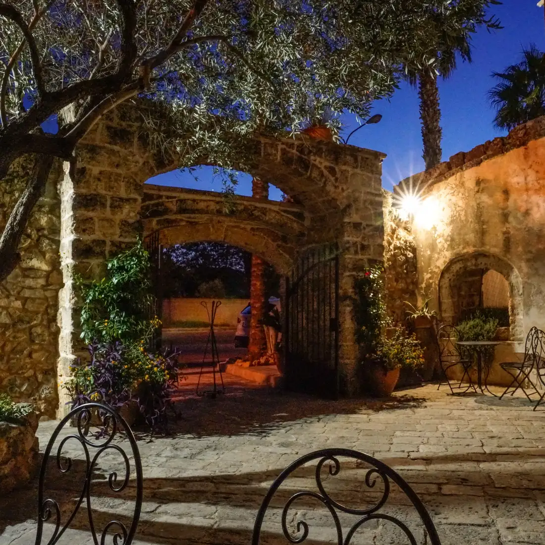 La corte esterna e l'arco in pietra illuminati all'ora blu