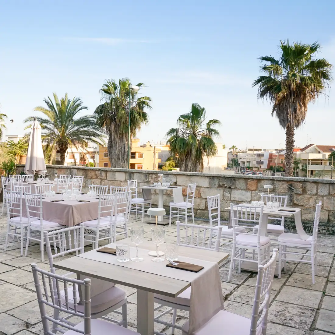 La terrazza con i tavoli apparecchiati tra le palme